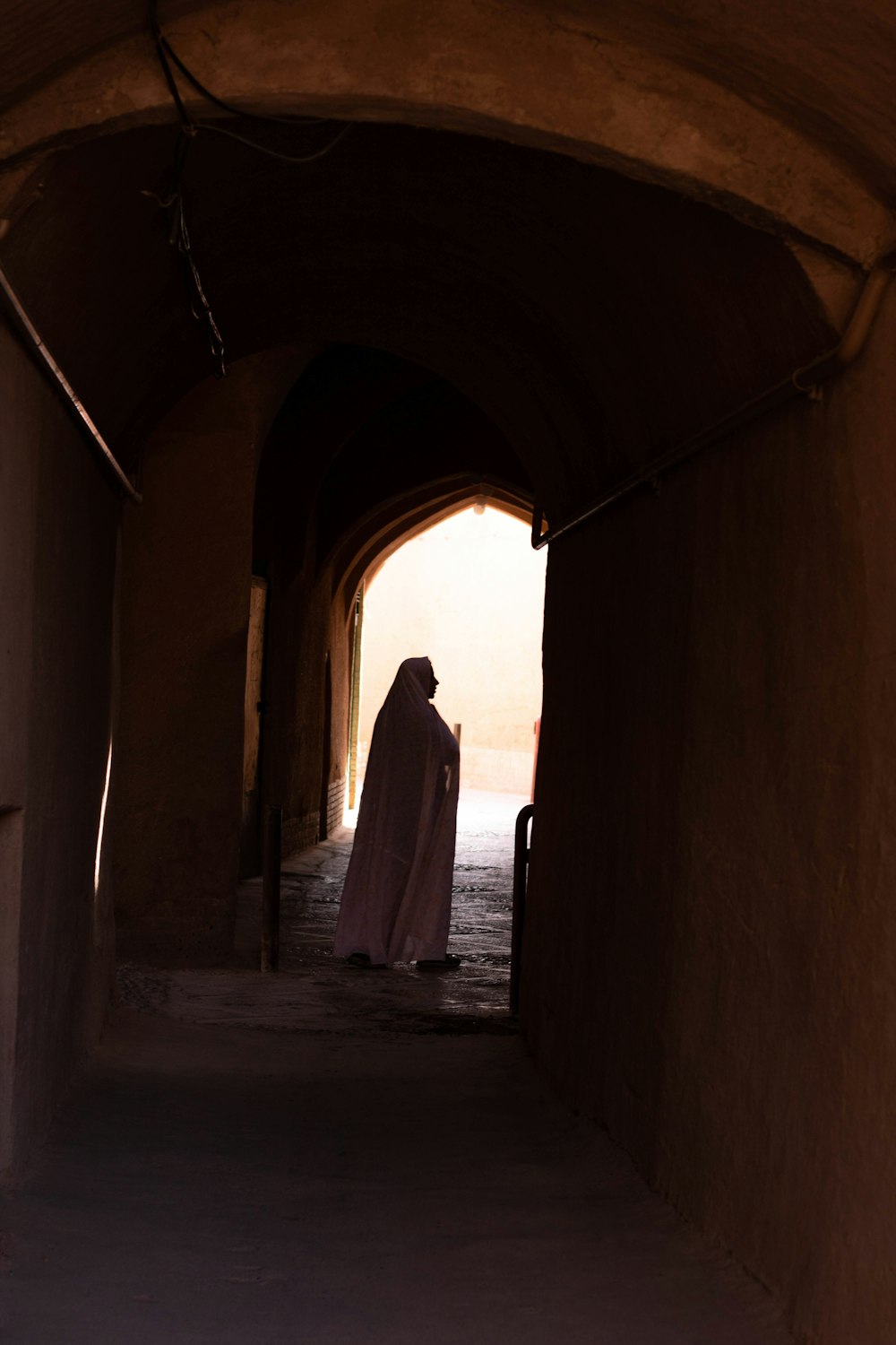 woman in white dress walking on hallway during daytime
