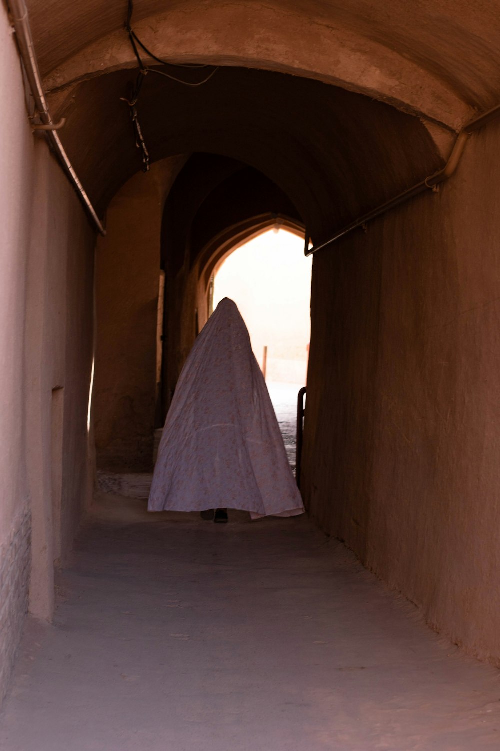 white textile on brown concrete hallway