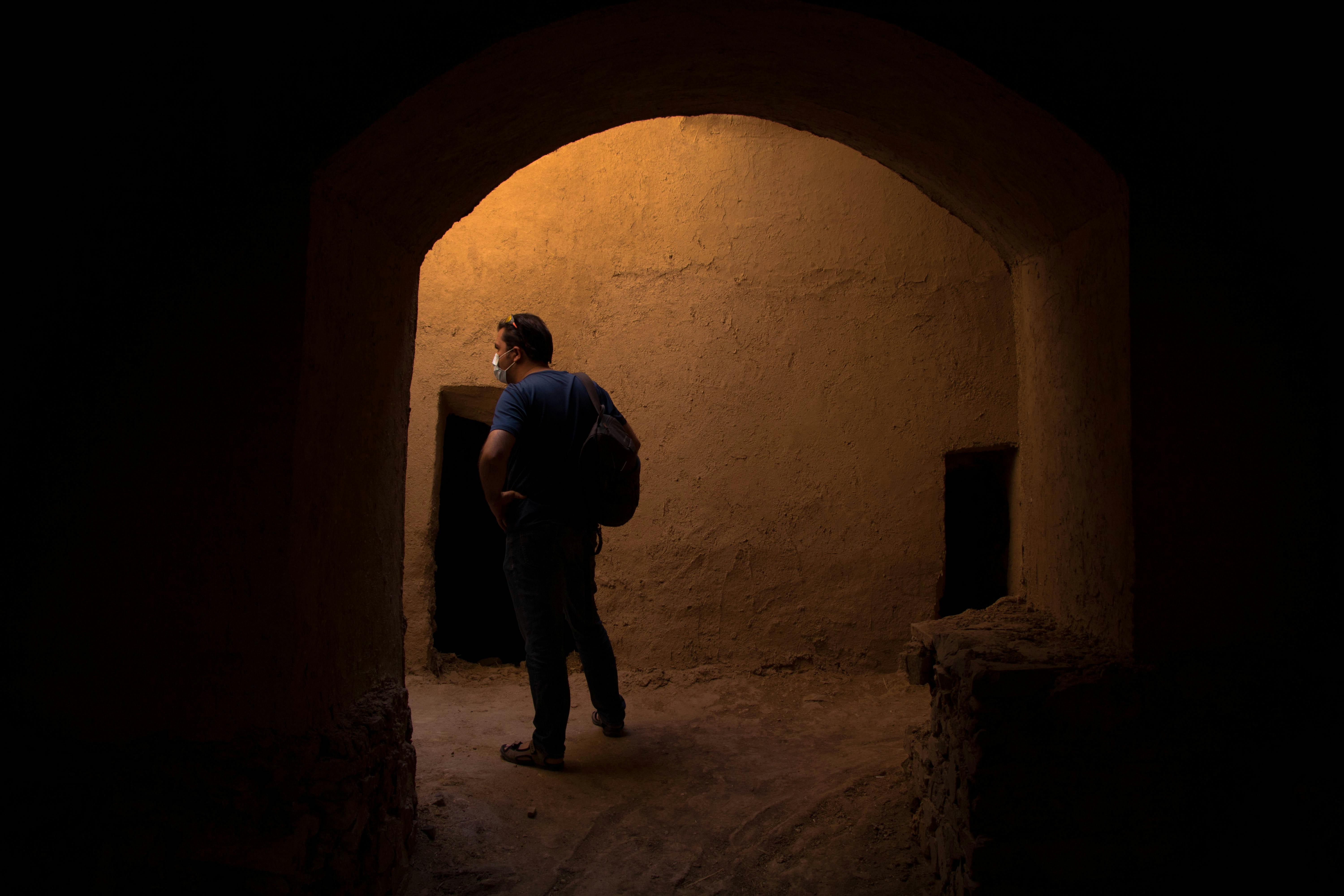 man in black jacket and pants standing in tunnel