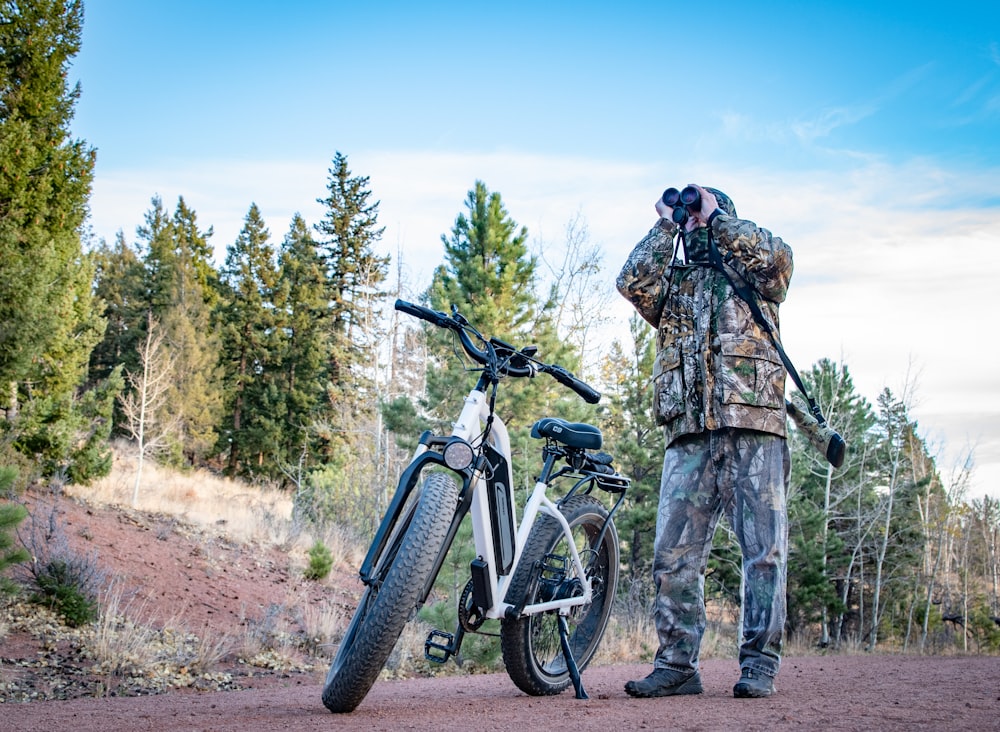 2 men standing on dirt road near mountain bike during daytime