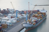 Close-up of refined oil products being loaded onto a ship at a busy port.