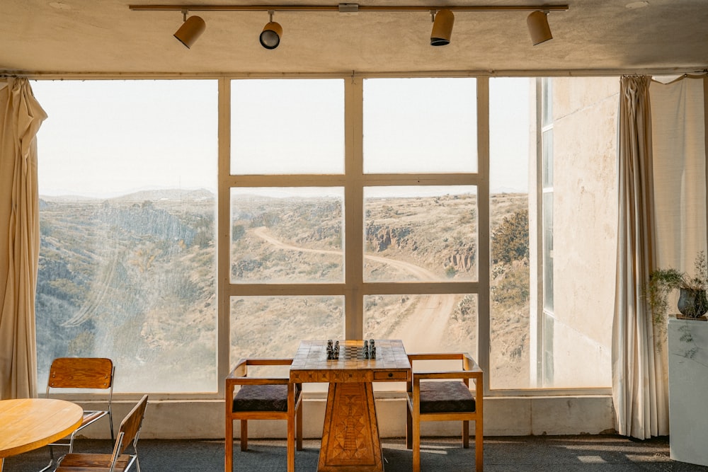 창문 근처의 갈색 나무 테이블과 의자