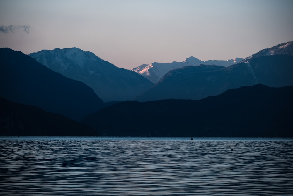 body of water near mountains during daytime