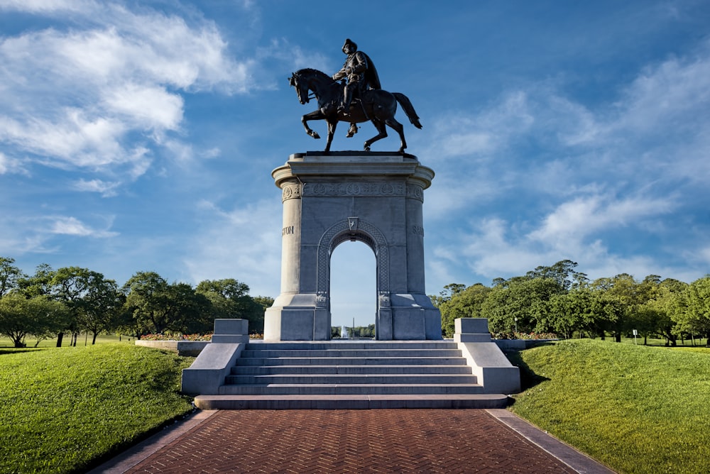 estátua preta do cavalo sob o céu azul durante o dia