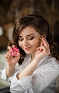 woman in white shirt holding red round fruit