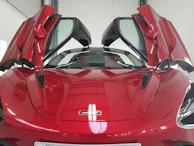 Close-up of a gleaming red Ferrari 488 Spider with its doors open, inviting you to experience speed and style.