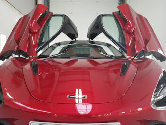 Close-up of a gleaming red Ferrari 488 Spider with its doors open, inviting you to experience speed and style.