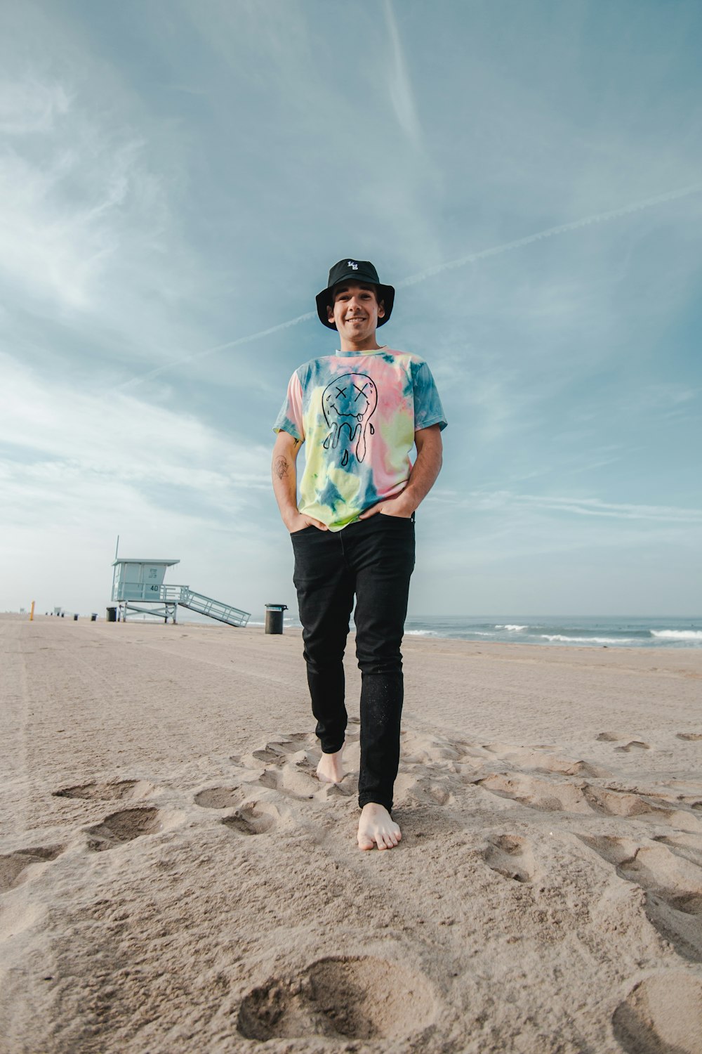 man in blue shirt and black pants standing on beach shore during daytime