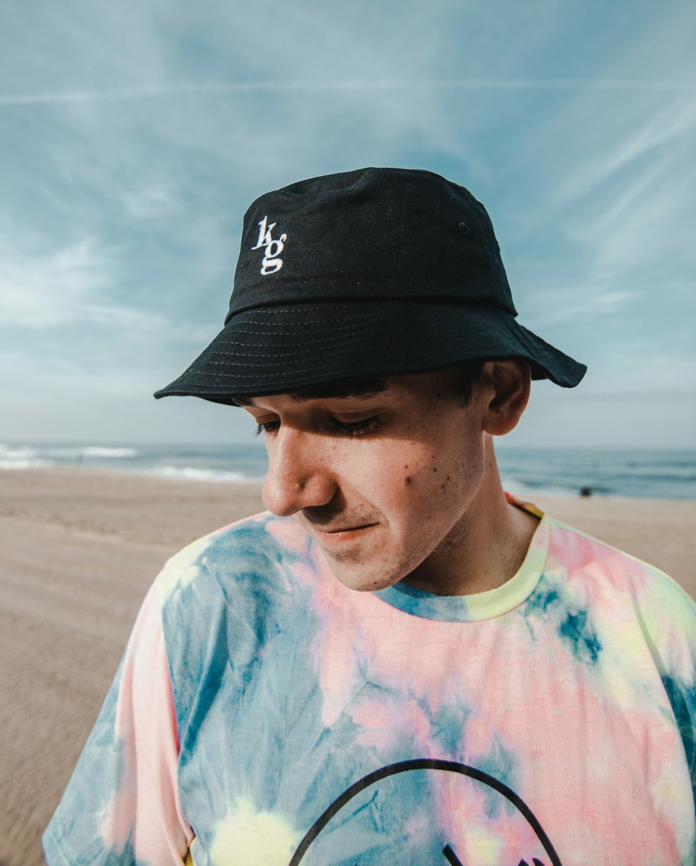 man in white blue and red crew neck shirt wearing black cap