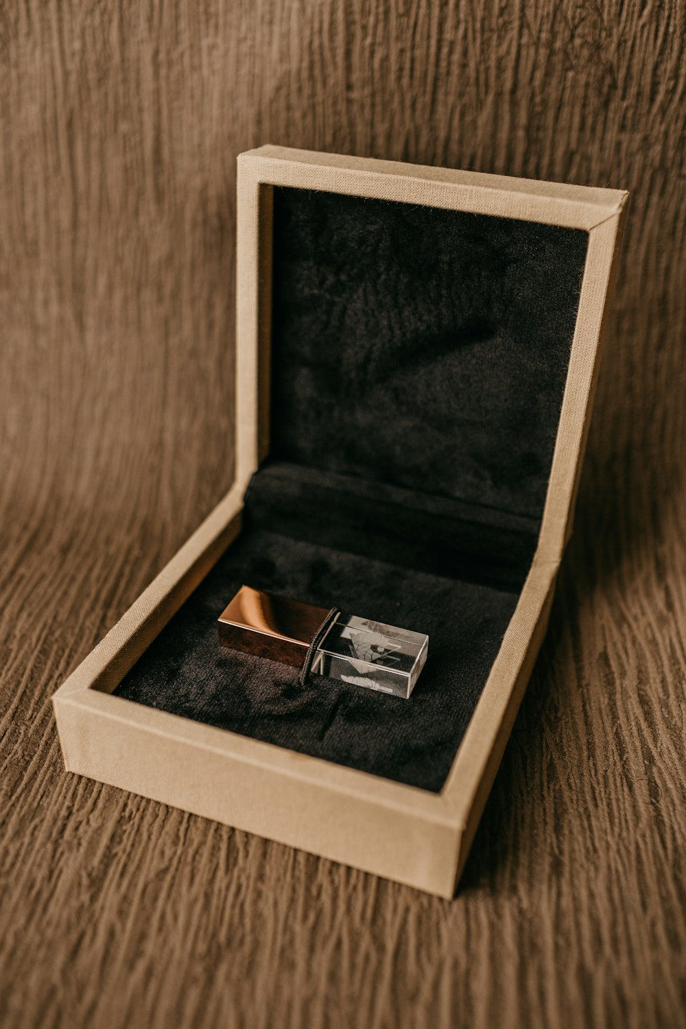 silver ring in box on brown wooden table