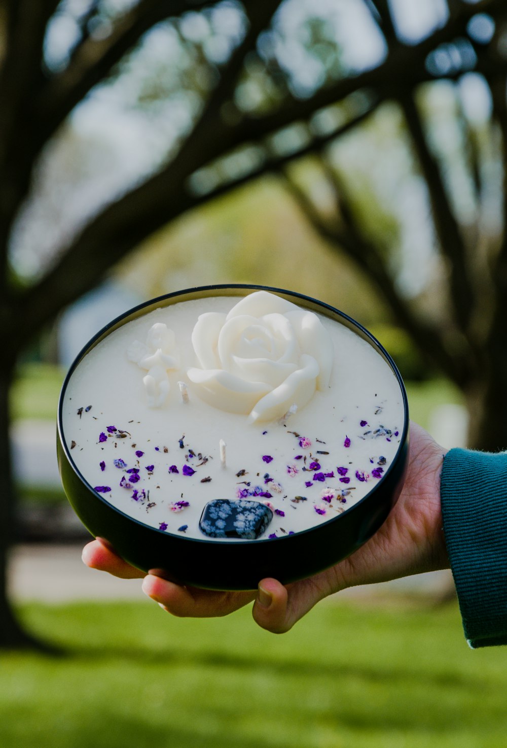 person holding clear glass with white cream