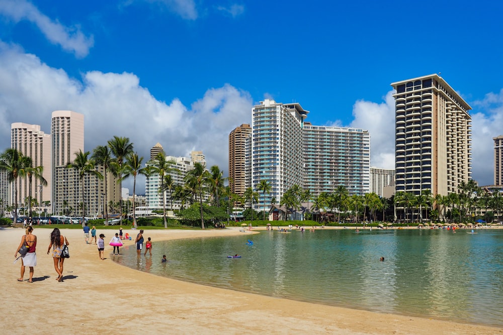 people on beach near high rise buildings during daytime