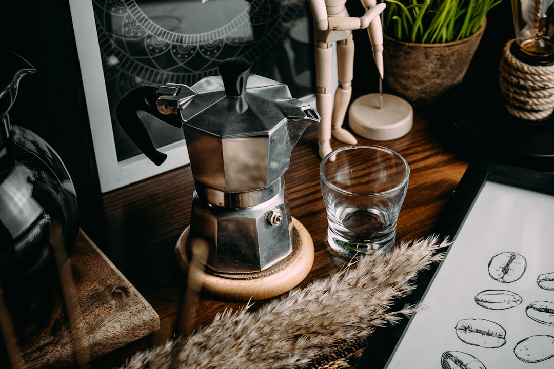 silver and black coffee maker on brown wooden table