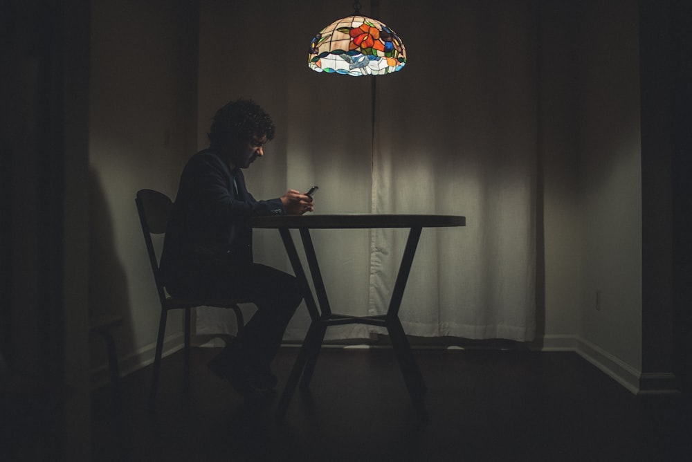 man in black shirt sitting on chair