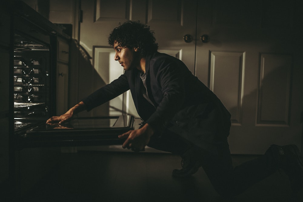 man in black long sleeve shirt sitting on brown wooden table