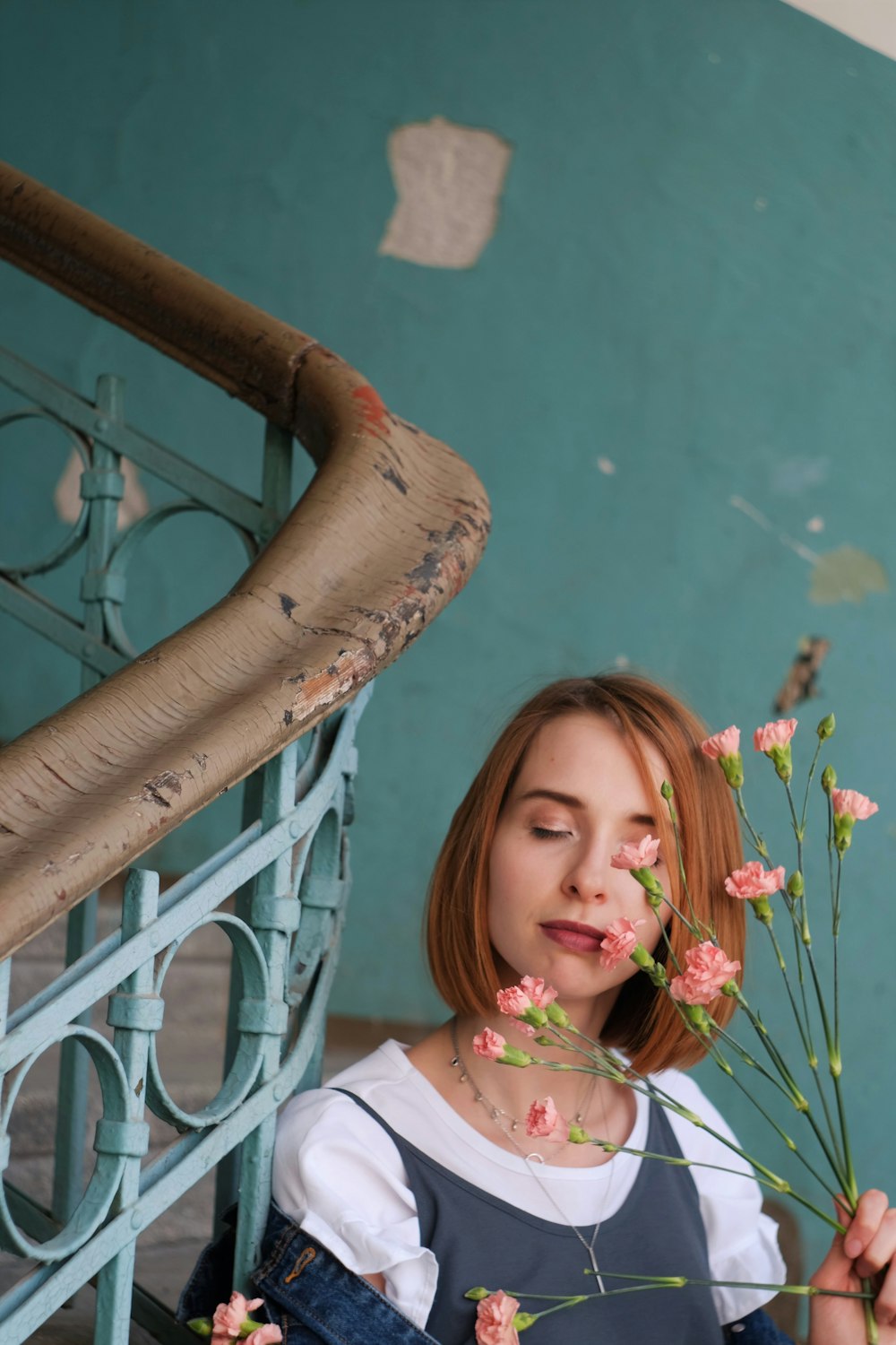 girl in white shirt holding pink flower