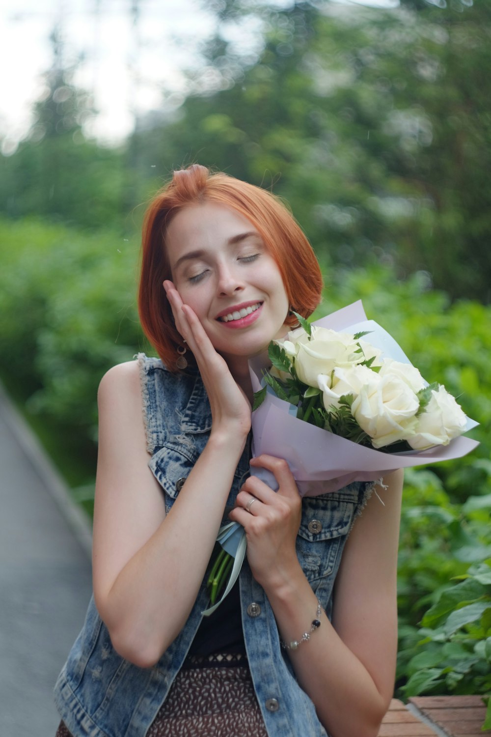 mulher no vestido azul sem mangas segurando buquê de flores brancas