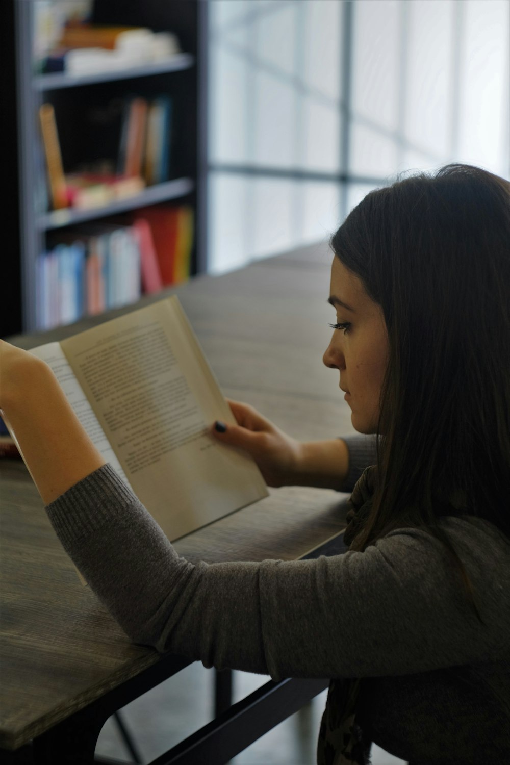 woman in gray t-shirt reading book