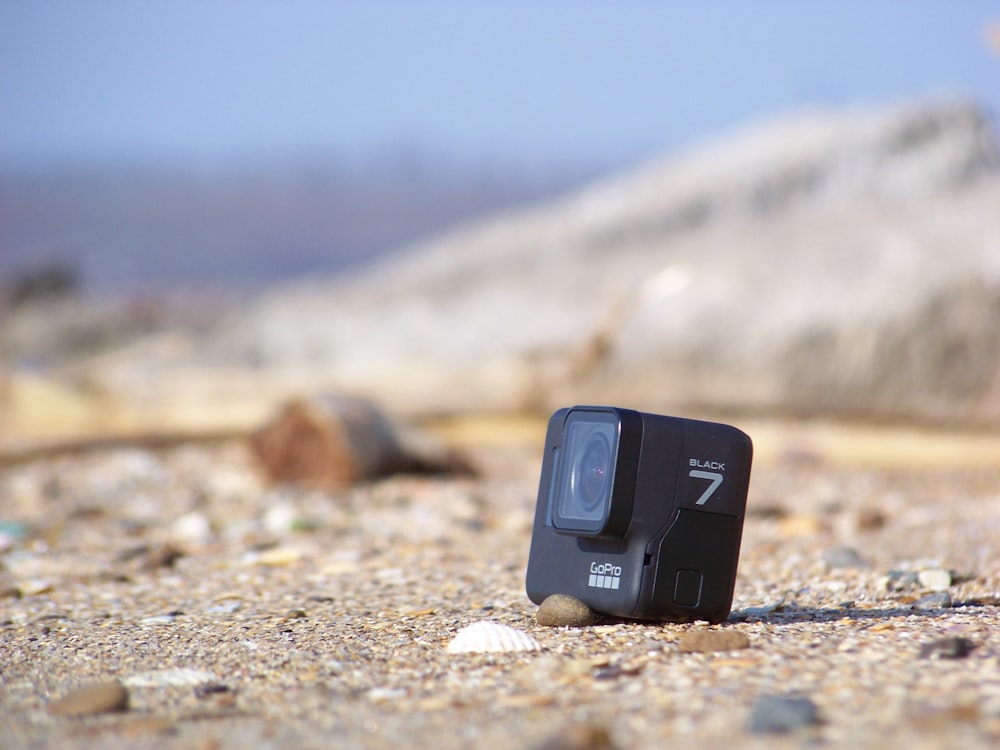 black and gray electronic device on brown sand during daytime