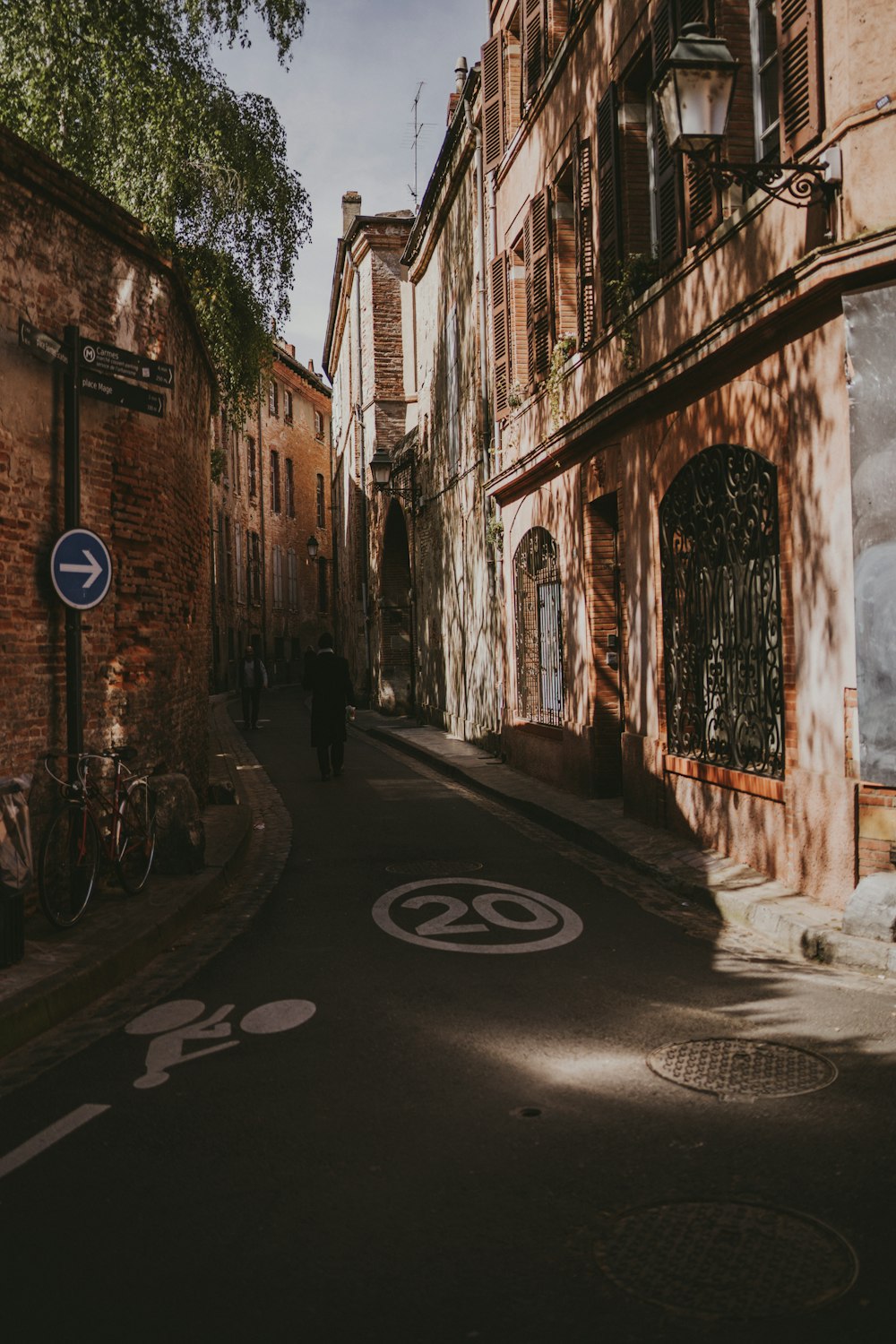 empty street with cars parked beside buildings during daytime