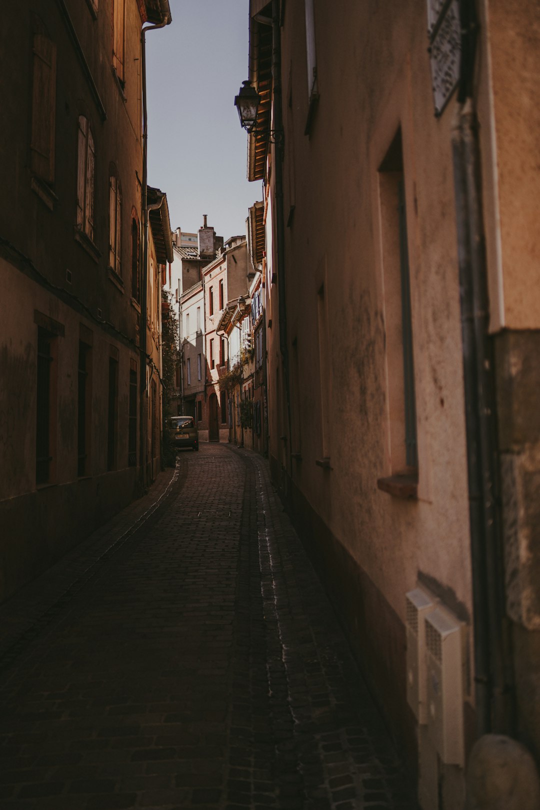 empty street between concrete buildings during daytime