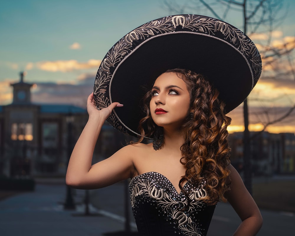 woman in black and white floral hat and black tube dress