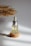 Close-up of a small amber glass bottle with a dropper, surrounded by fresh herbs and soft natural light.