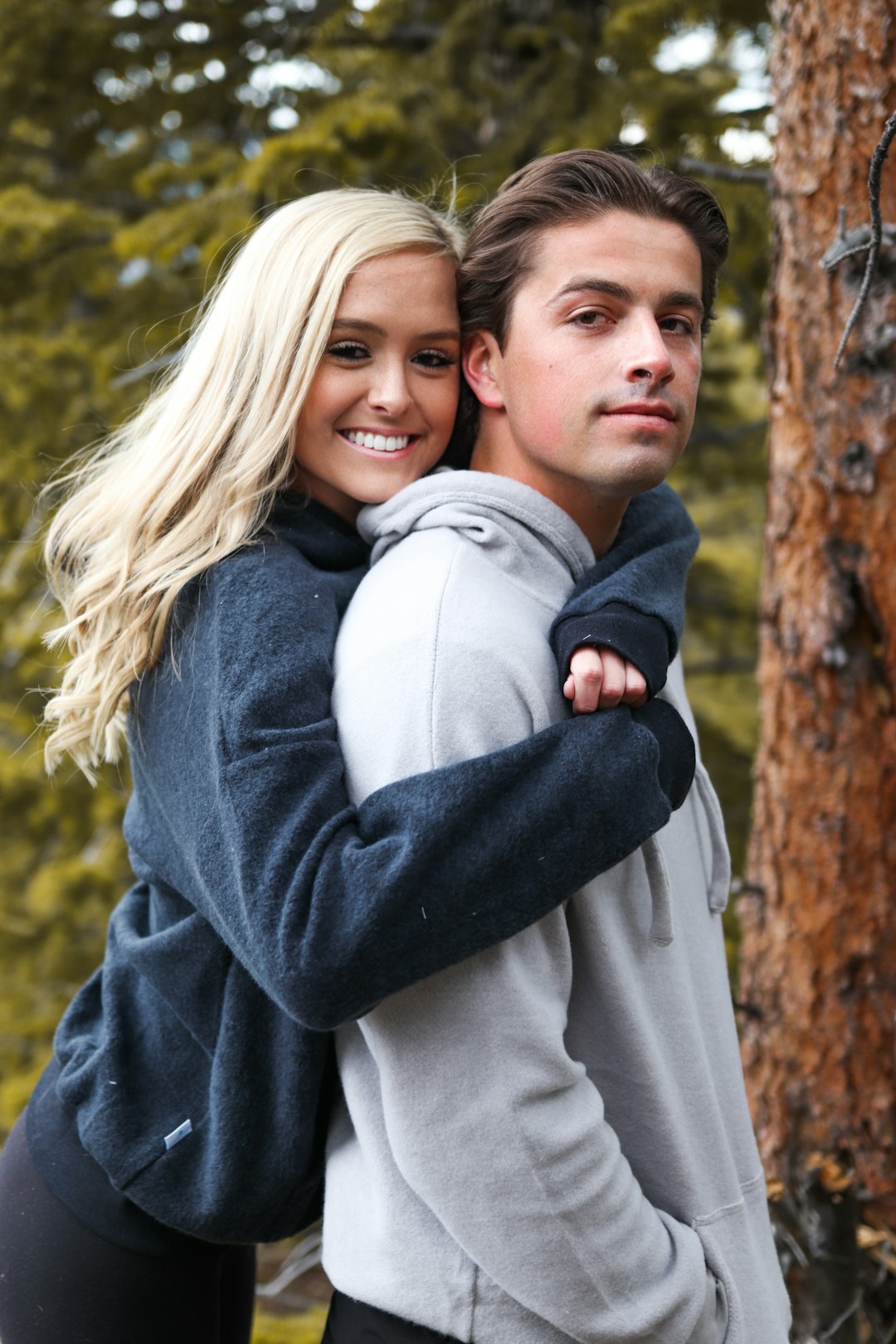 woman in gray long sleeve shirt hugging girl in black jacket