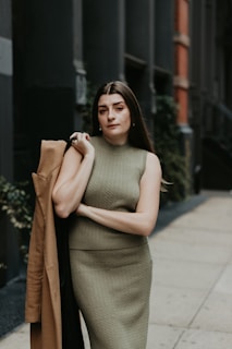 A cozy knit dress paired with ankle boots, set against a city street backdrop