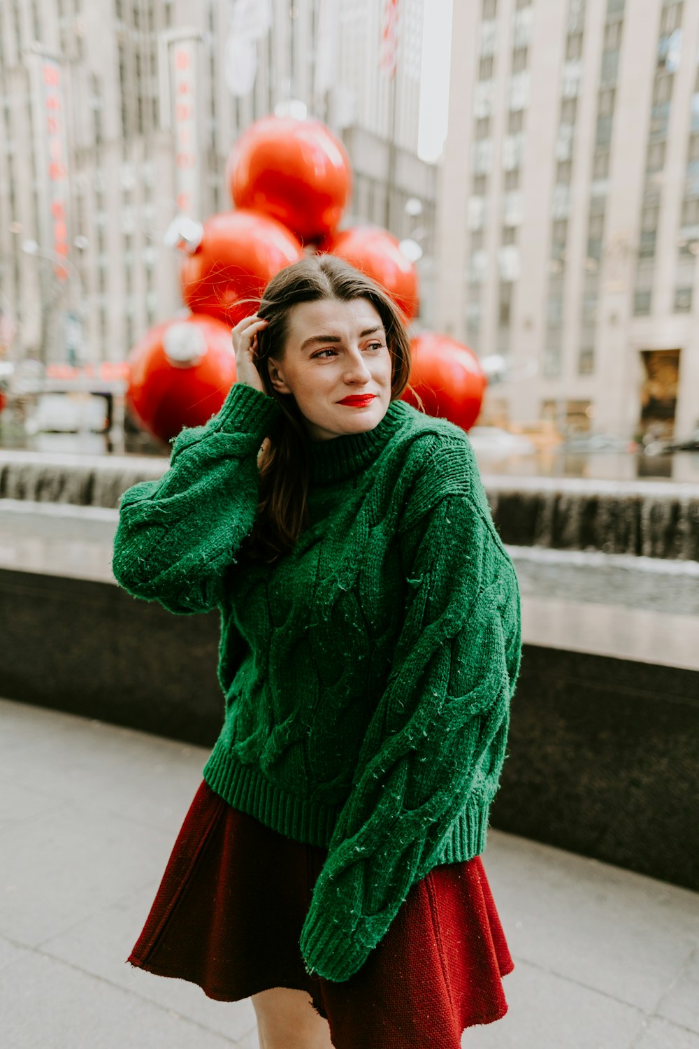 Foto Mujer en suéter de punto verde y falda roja sosteniendo globos de  corazón rojo – Imagen Nueva York gratis en Unsplash