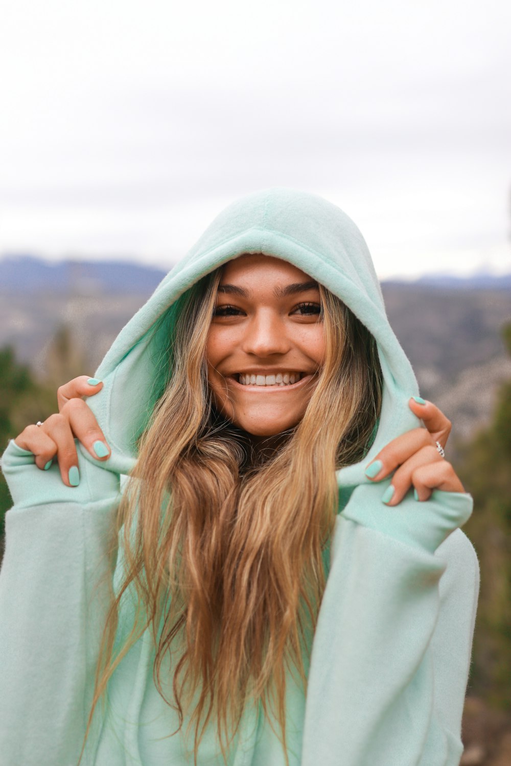 donna sorridente in felpa con cappuccio bianca