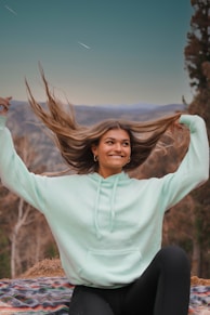 woman in white long sleeve shirt standing on brown grass field during daytime