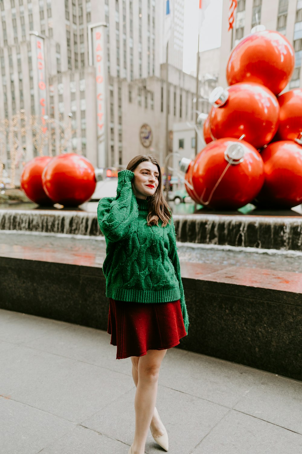 woman in green long sleeve dress holding red balloons