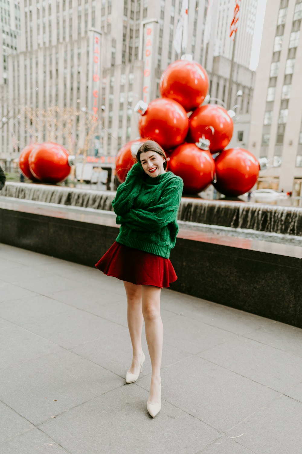 woman in green long sleeve dress holding red balloons