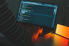 A developer happily working on a laptop with fade-up animations visible on the screen.