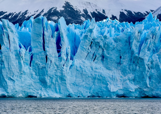 white and blue ice on body of water during daytime