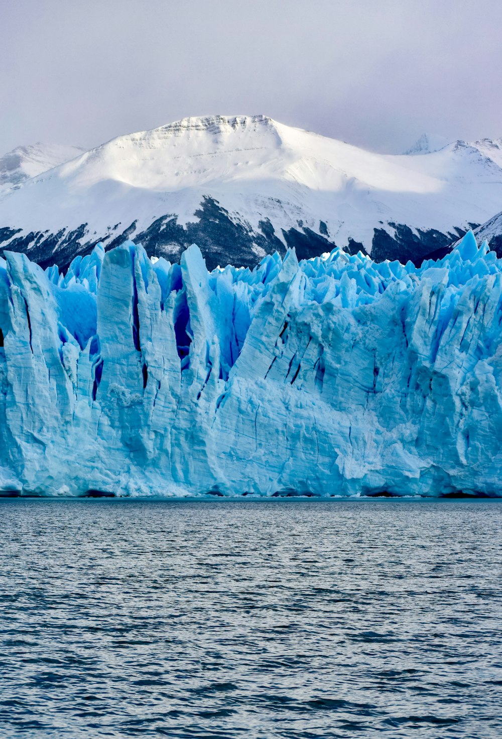 white and blue ice on body of water during daytime