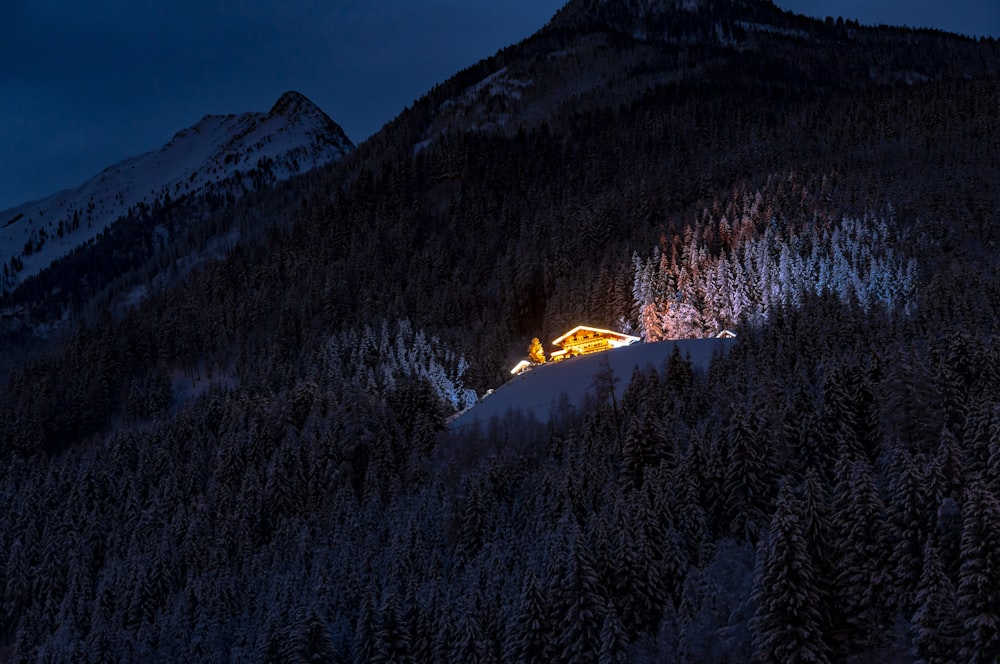 brown house on snow covered ground near mountain during night time