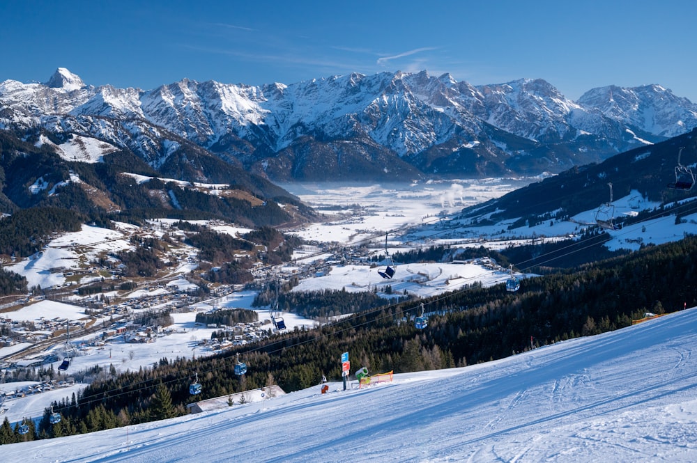 people walking on snow covered ground near snow covered mountains during daytime