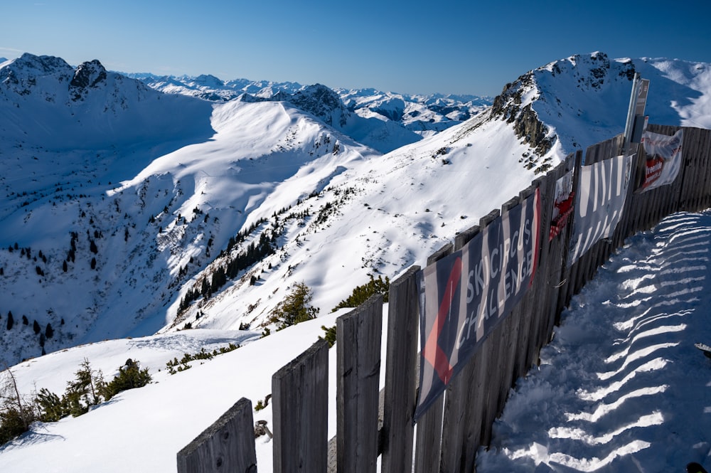 brown wooden fence on snow covered mountain during daytime