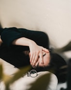woman in black long sleeve shirt covering her face