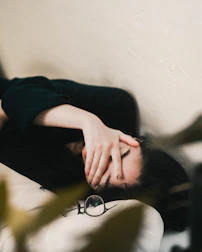 woman in black long sleeve shirt covering her face