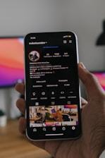 person holding smartphone with instagram page showing the grid and creative content
