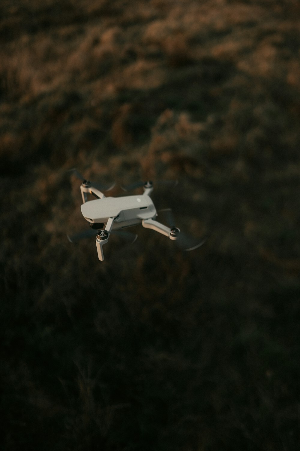 white drone flying in mid air