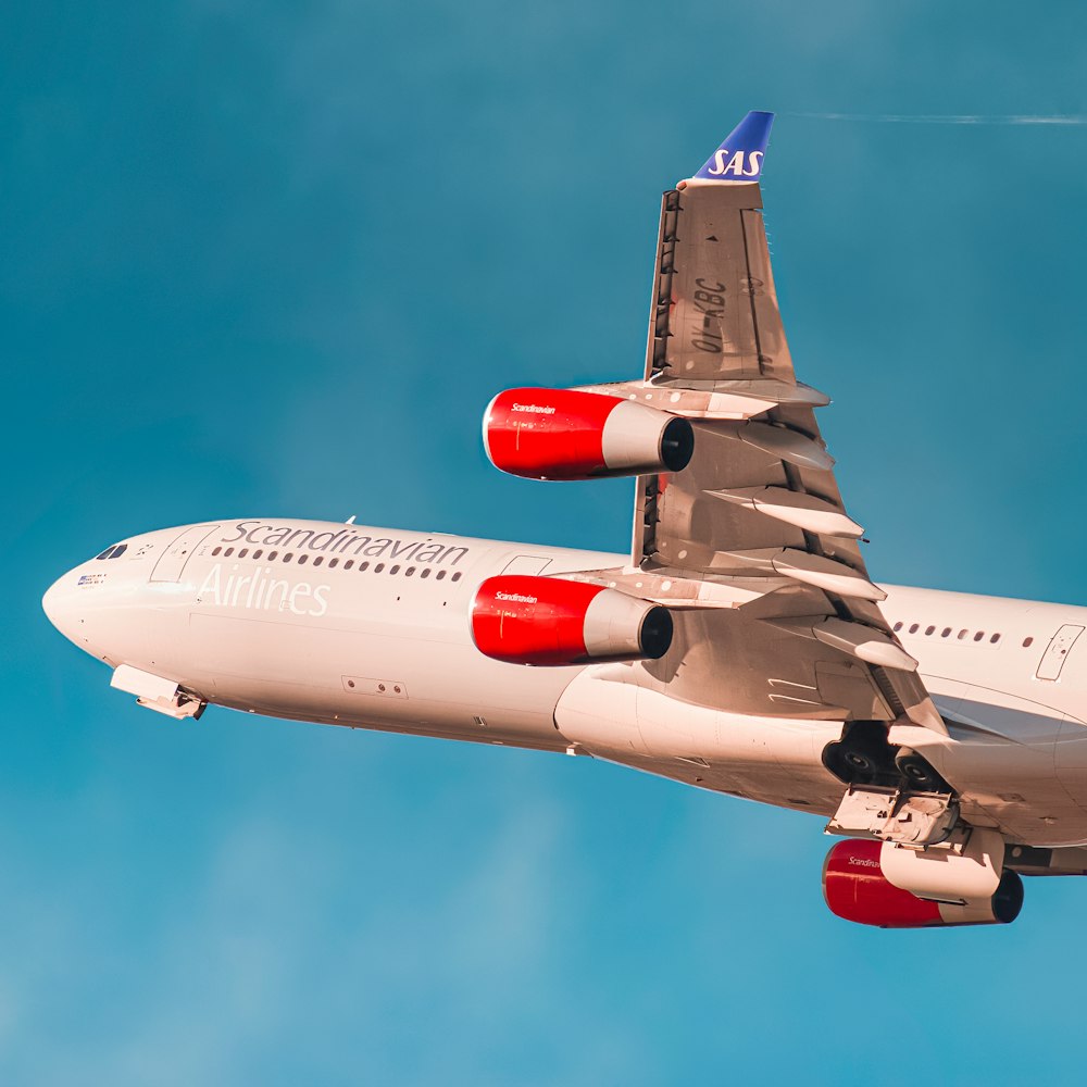 white and red passenger plane in flight