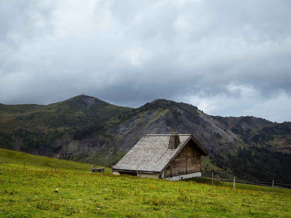 white and gray house on green grass field near green mountain under white clouds during daytime