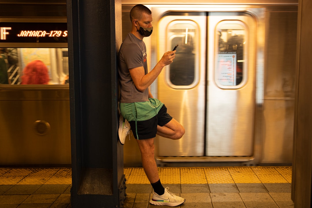 man in gray crew neck t-shirt and green shorts standing beside white wooden door