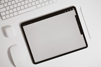 A minimalist desk setup featuring a digital planner on a tablet.