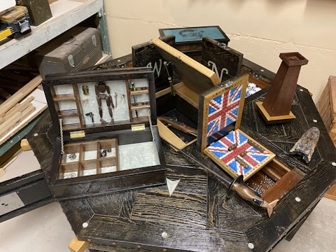 Various munitions displayed on a wooden table with tools.