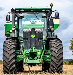 green and black tractor on brown grass field during daytime